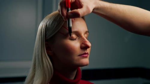 in a Plastic Surgery Clinic a Doctor Makes Markings on the Face of a Young Girl Before Surgery