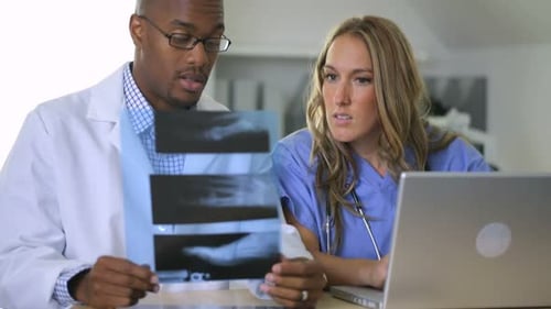 Doctors Reviewing X-Ray Images Together on Laptop