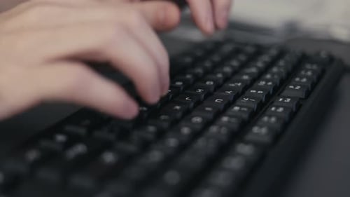 Manos de hombre escribiendo en el teclado de la computadora escribiendo texto