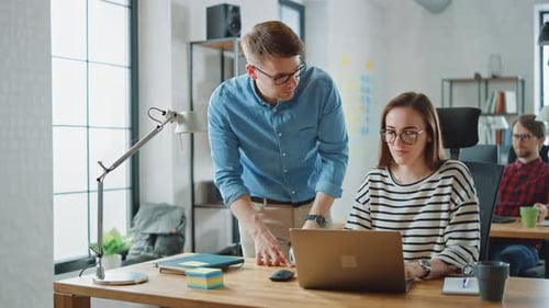 Young Casual Business Couple are Using Laptop in Creative Agency Loft. Friendly Easygoing Coworking