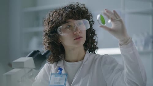 Scientist Examining Leaf Sample in Petri Dish
