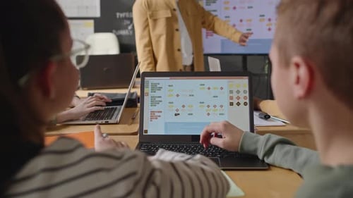 Schulkinder diskutieren Computeralgorithmen auf dem Laptop-Bildschirm