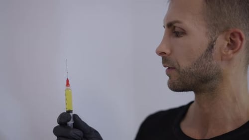 Un médecin observe une seringue contenant le Prp extrait