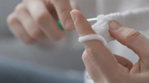 Woman crafts with hook and white yarn indoors