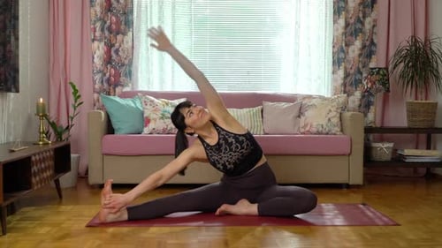Woman Practices Seated Yoga Pose Indoors