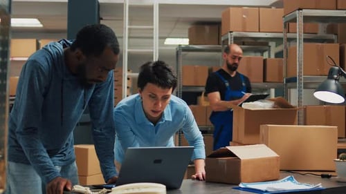 Büroangestellte arbeiten zusammen, um Waren in Pappkartons zu versenden