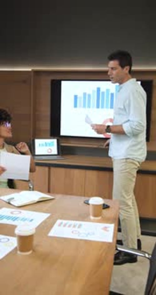 Vertical video: Diverse coworkers leaning in after chart pointing and analyzing data