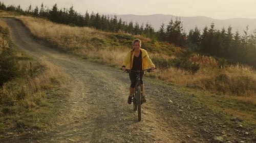 Smiling sportswoman enjoying a bike ride on a mountain road in summer