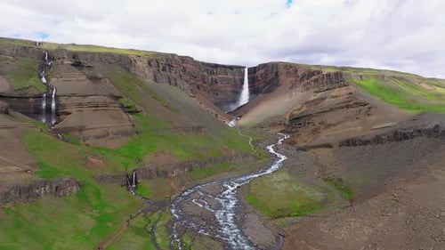Aerial view of Hengifoss waterfall in lush valley, Iceland.