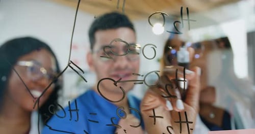 Serious doctors scientists working over new formula and writing it on glass board in scientific labo