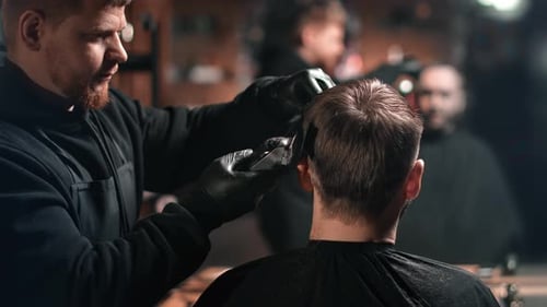 Barber Cuts Hair with Electric Razor