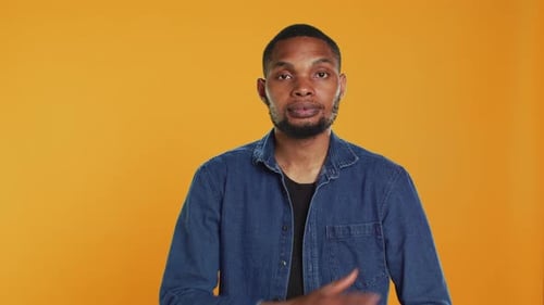 Portrait of African American Casual Man Posing Against Orange Background
