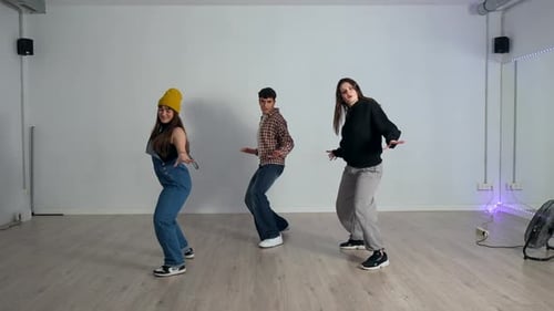 Young dancers performing choreography in dance studio