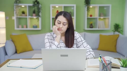 Tired and sleepy woman working in home office.