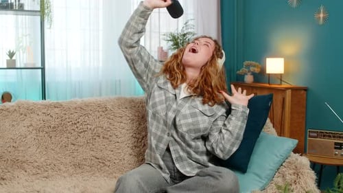 Energetic Young Adult Singing at Home with Microphone