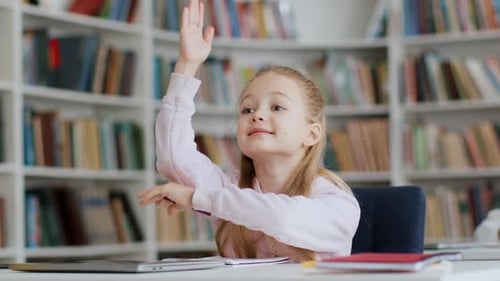Child Raises Hand in School Library