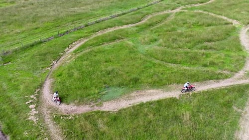 Dirt Bikes Riding on Green Grassy Hills