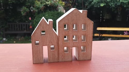 Miniature wooden house ornament in garden mortgage concept idea in recession