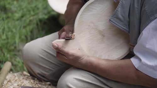 Man Crafting Wood with a Small Knife
