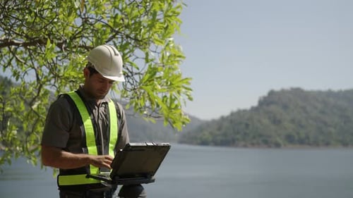 Blue collar worker is working at the dam.