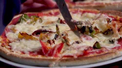 Close-Up of Pizza Being Cut with Knife