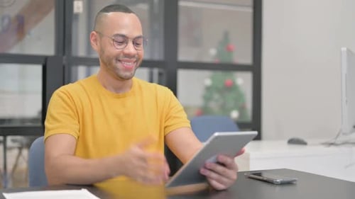 Young Adult Man Celebrates Using Tablet in Office