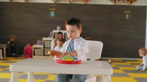 Rainbow toy game. Group of children are in the kindergarten.