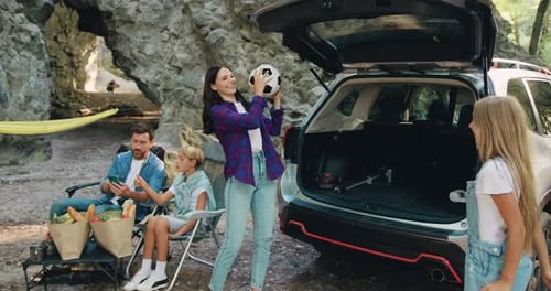 Family Fun With Soccer Ball Outdoors by Car