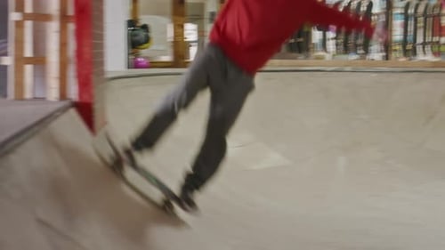 Skateboarder Skating Ramp and Bowl at Indoor Skatepark