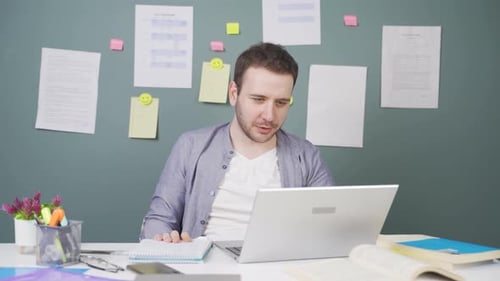 Man Video Conferencing While Working at Desk