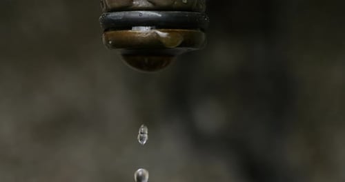 Water Droplets Falling from a Metal Faucet