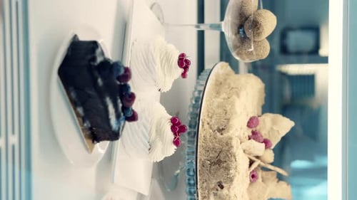 Close-up of sweet confectionery desserts behind a showcase.Cake, pastries, meringue in a shop window