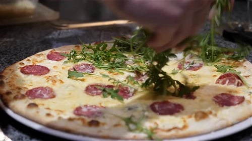 Pizza Topped with Arugula Being Prepared in Restaurant