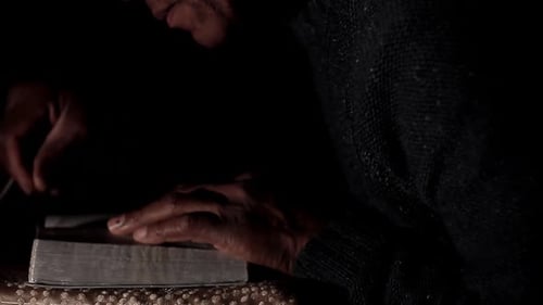 Mit der Hand auf der Bibel auf schwarzem Hintergrund mit Menschen zu Gott beten — Stock-Bildmaterial