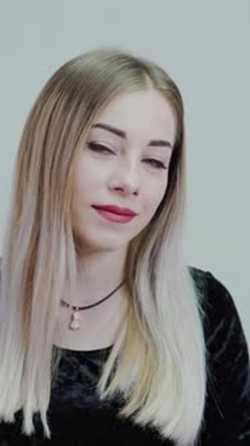 Blonde Haired Woman Smiles Gently at Camera