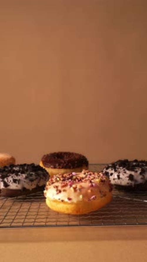 Hand Placing Donut on Cooling Rack in Minimal Studio Background
