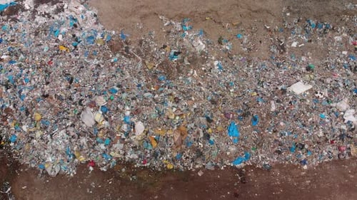 Aerial lift off establishing shot over a large landfill of garbage.