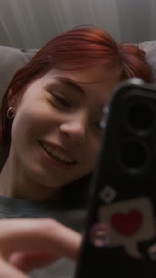 Teenager Scrolling in Smartphone and Laughing at Video in the Internet