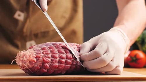 Close Up of Person Cutting String From Beef Roast