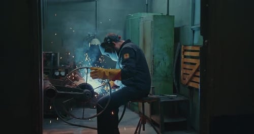 Professional Welder Works in a Workshop at the Factory