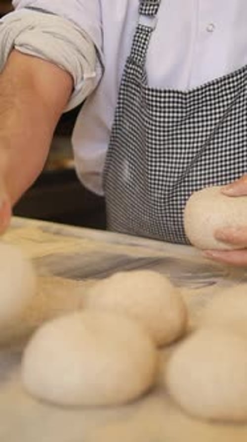 Baker Kneading Dough Balls in a Bakery