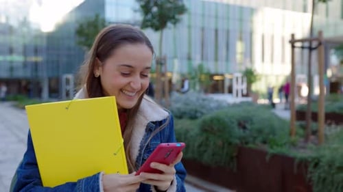 Young Caucasian Student Girl Using Phone at College Campus After Classes