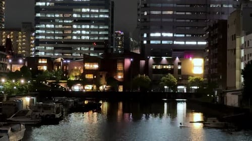 Night view of illuminated city buildings reflecting in the water