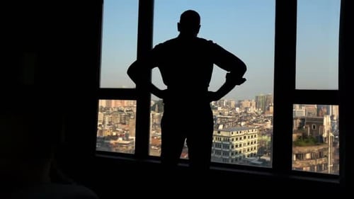 Man silhouette admire city view from apartment window enjoying urban lifestyle
