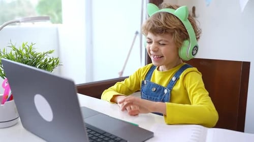Cute Smart Caucasian Primary School Child with Headphones Video Call Conference Educate Online