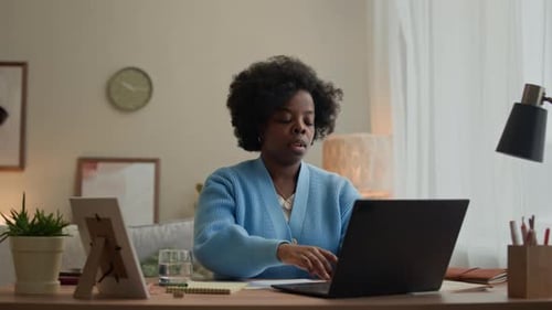 Woman working from home stretches at her desk