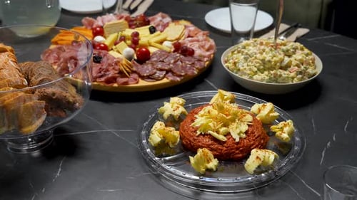 Christmas Dinner Table with Steak Tartare, Cold Cuts, Cheese Platter and Salad