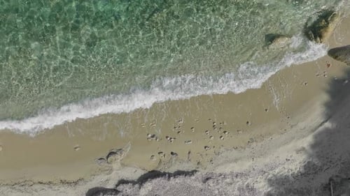 Aerial View of Turquoise Water Lapping Sandy Beach