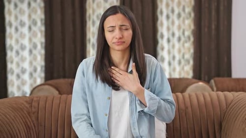 Woman Experiencing Heartburn or Acid Reflux on Couch