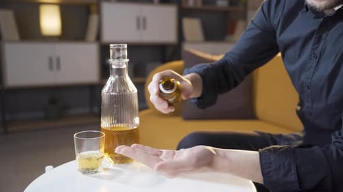 Man Pouring Pills Into Hand at Home